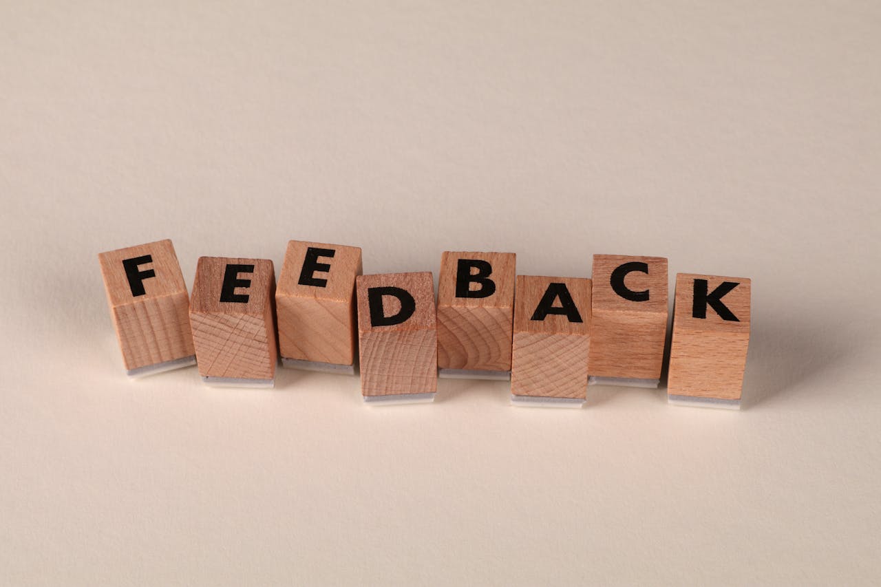 Wooden letter blocks arranged to spell FEEDBACK on a neutral background. Ideal for communication concepts.
