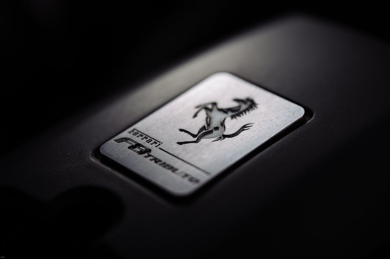Close-up of a metallic car logo badge with a prancing horse, symbolizing luxury and speed.